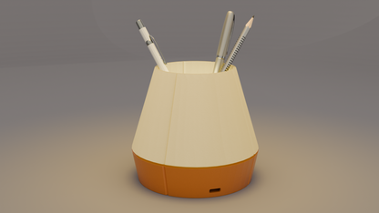 The Litele Duo Orange lamp, lit and functioning as a pen holder, with pens inserted